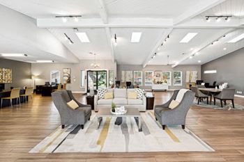 a living room with couches and chairs and a rug at The Reserve At Barry Apartments, Kansas City, MO